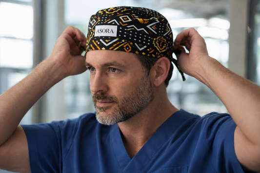 Person wearing a blue scrub top and patterned scrub cap with 'ASORA' branding.