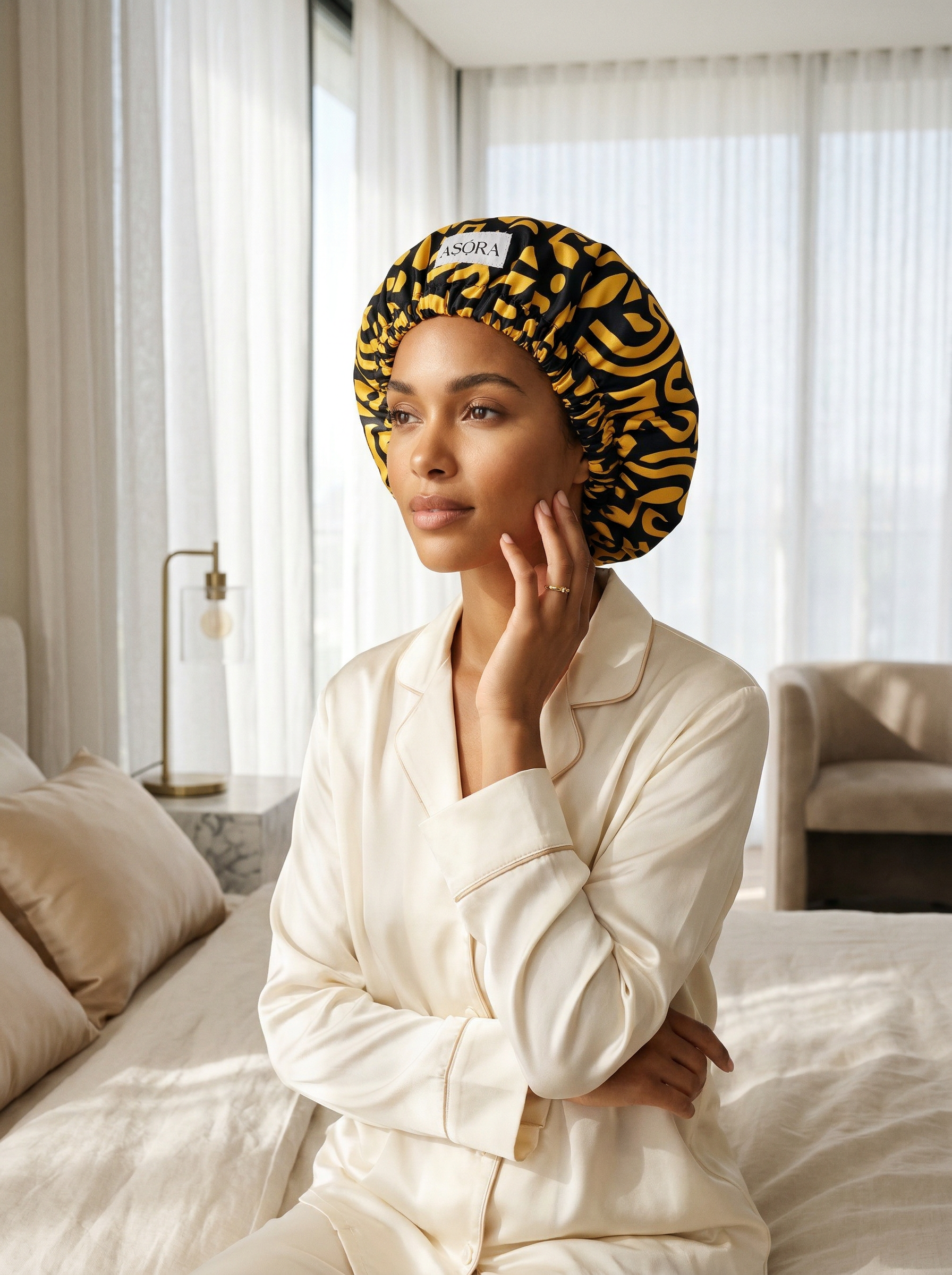 ASORA, Woman wearing a yellow and black patterned bonnet in a bedroom.