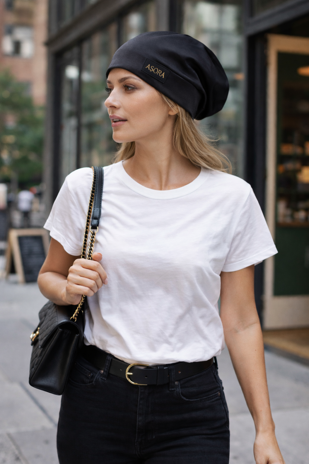 Woman wearing a black ASORA slouch cap and white t-shirt on a city street