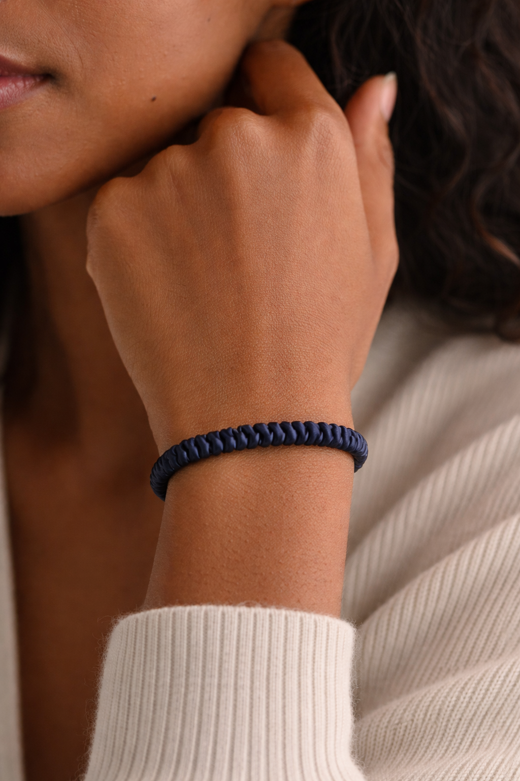 AsoRA, Close-up of a person wearing a navy blue silk scrunchie  on a blurred background