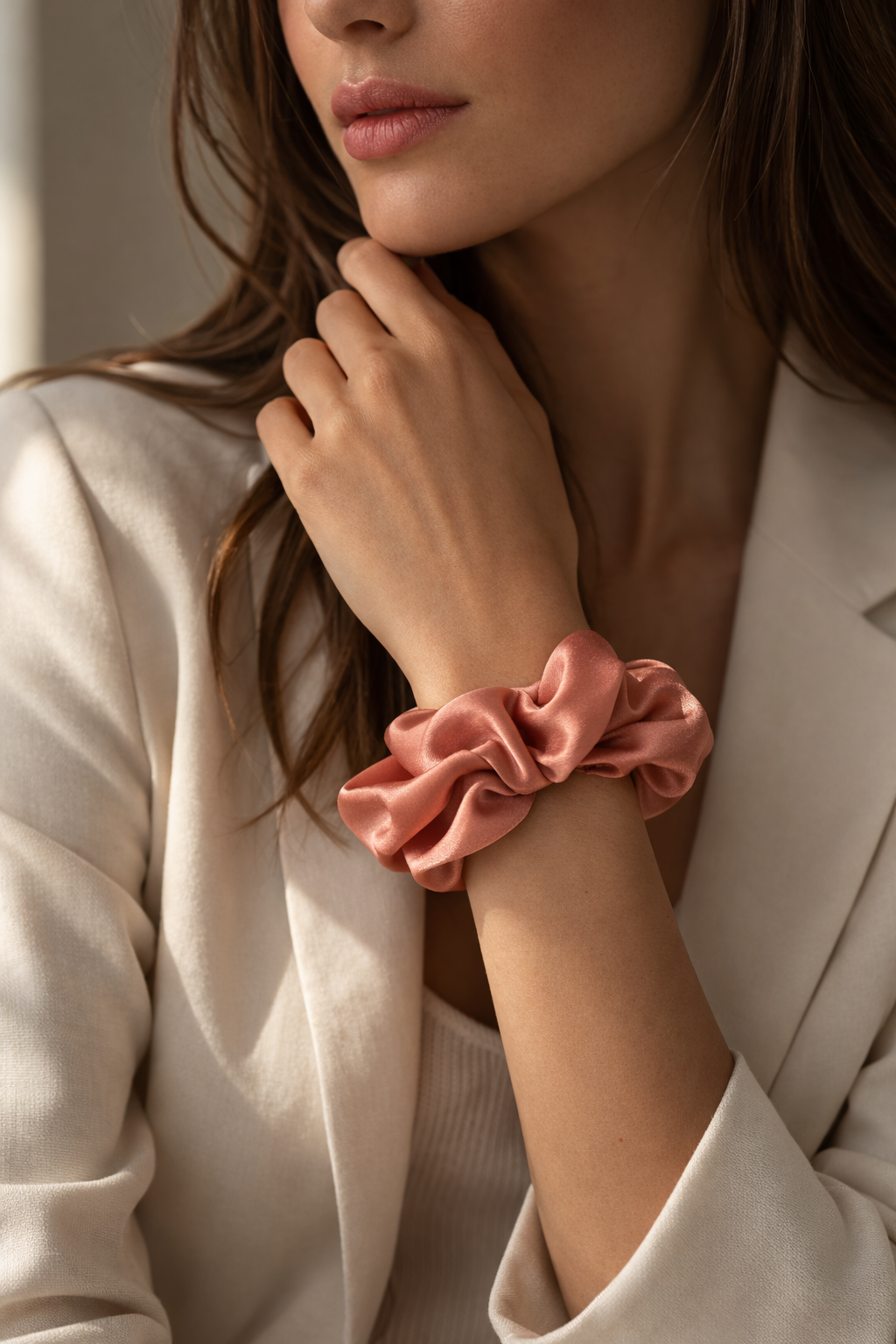ASORA Silk Scrunchie, Woman wearing a pink scrunchie on her wrist, with a neutral background